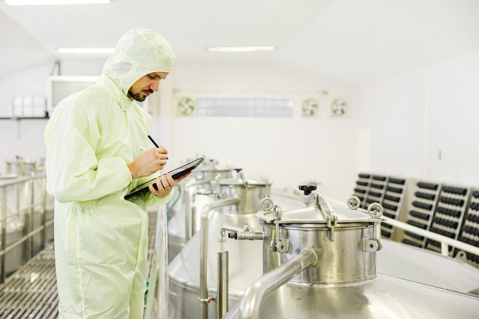 Food beverage worker working check fermentation tank with clean hygiene condition workplace.